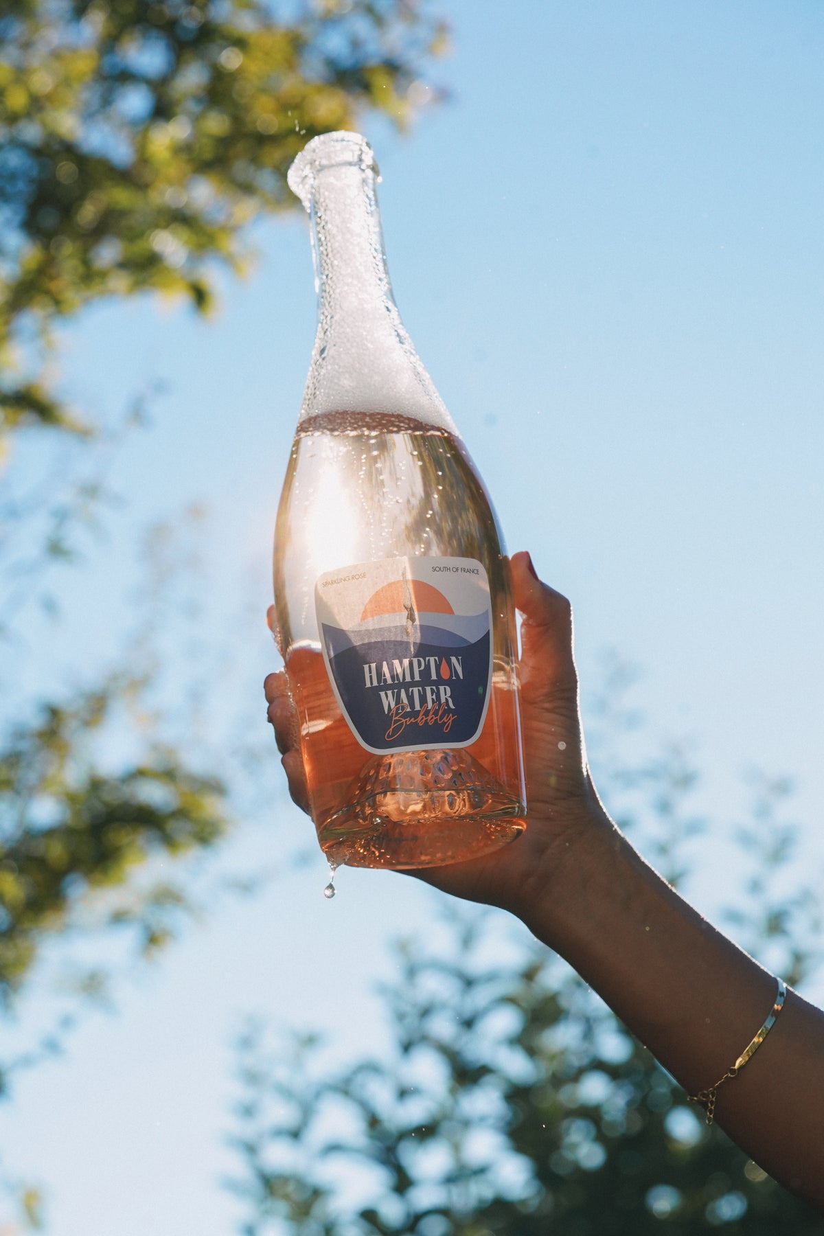 Hampton Water Bubbly being held up in front of the sky